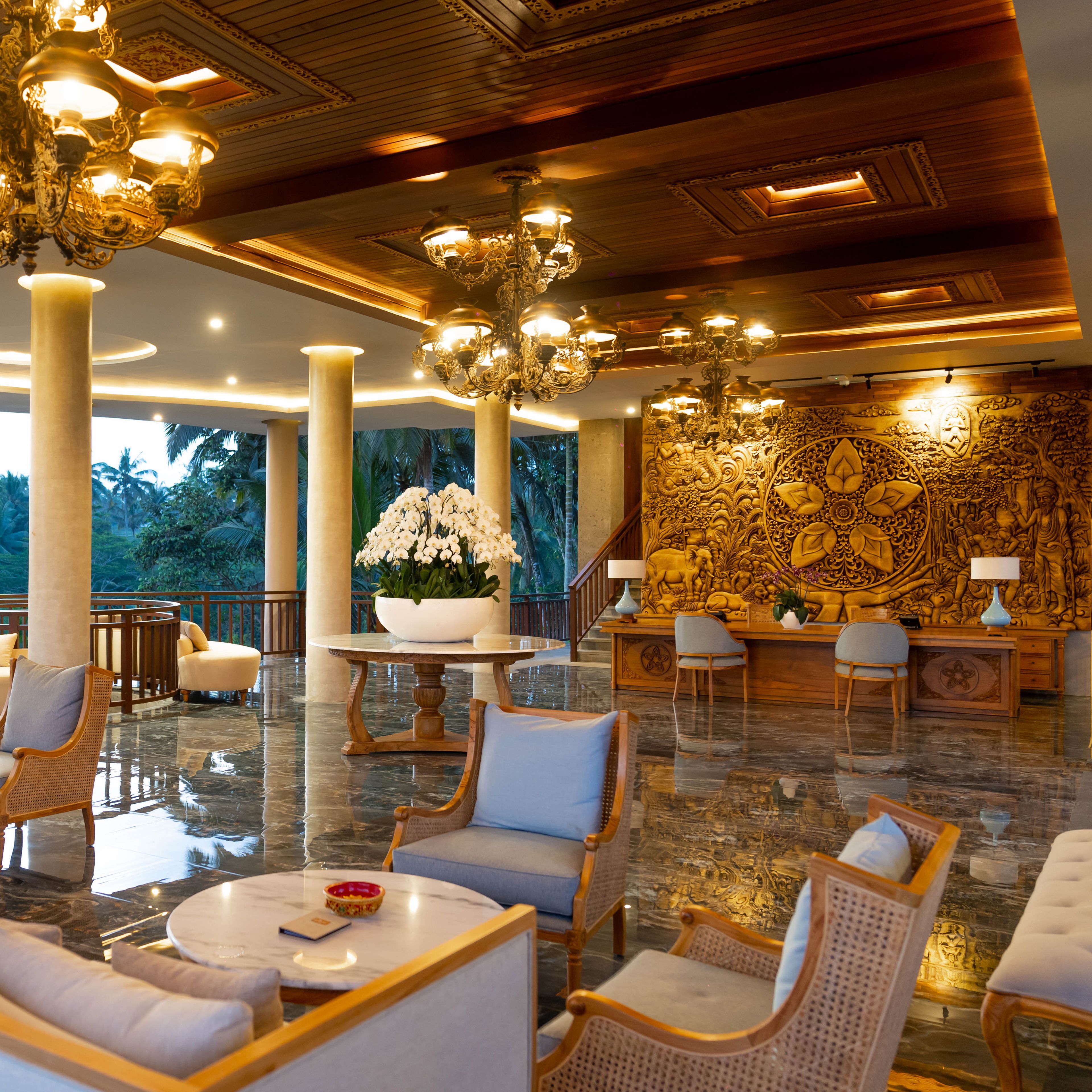 Eine geräumige Lobby mit hoher Decke, aufwändigen Kronleuchtern, einer großen Blumenkomposition und einer detailreichen Wandrelief.