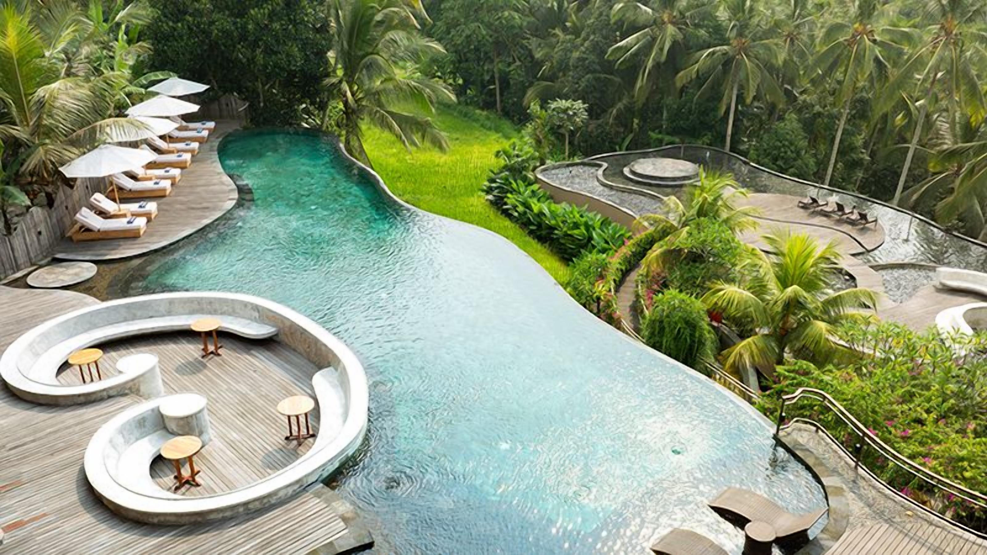 A pool area with lounge chairs and a circular seating area.
