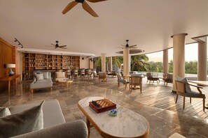 A spacious lounge area with a chessboard, comfortable seating, and a library. - Abisena Wellness & Resort Ubud Adult Only (Tegallalang)