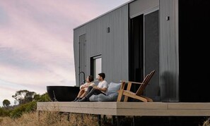 A modern building with a flat roof, large sliding glass doors, and a wooden deck. - Cabn Kangaroo Island (Ironstone)