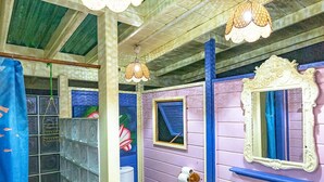 A bathroom with a shower, toilet, sink, and decorative elements like a mirror and hanging lights. - Fare Miti (Moorea-Maiao)
