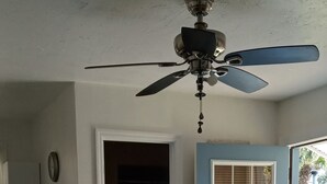 A room with a ceiling fan, a door leading outside, a coffee maker, and a mat at the entrance. - Charming 1-bedroom cottage in Port Orange Close to Daytona Beach  (Port Orange)