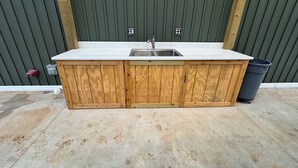 A wooden kitchen island with a sink and cabinets, against a green wall.