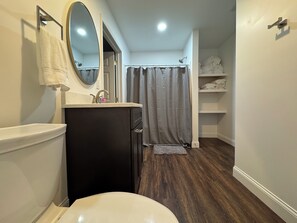 A bathroom with a toilet, sink, mirror, and shower curtain.