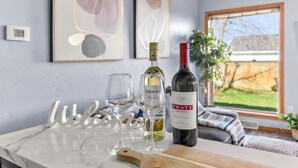 Un comptoir en marbre avec une bouteille de vin, deux verres à vin et une pancarte « Bienvenue ».