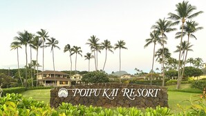 Schild für das Poipu Kai Resort, umgeben von üppiger Vegetation und Palmen.