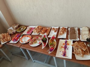 A table with various food items and bread. - The Nomad Pyramids Boutique Hotel (Giza)