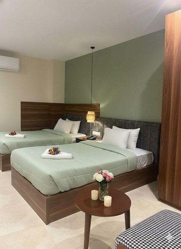 A hotel room with two beds, a small round table with candles, and a wooden headboard. - The Nomad Pyramids Boutique Hotel (Giza)