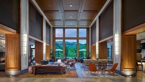 A spacious lobby with a high ceiling, large windows offering a mountain view, and a mix of seating areas including sofas and chairs. - Escape to the awe-inspiring beauty of Avon, Colorado and the Rockies (Avon)