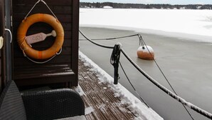Un muelle de madera con un flotador y una cuerda sobre un lago helado.