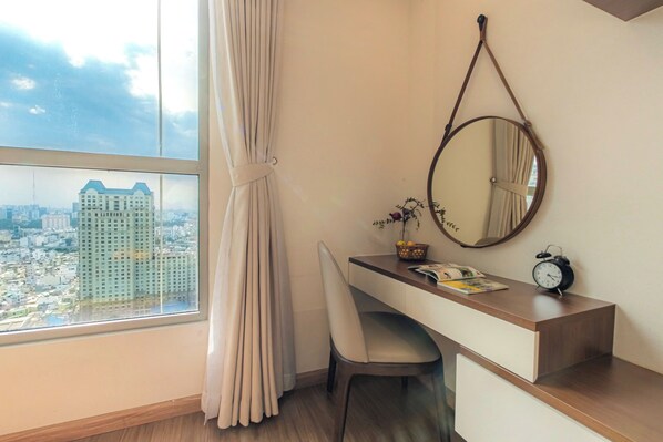 A room with a desk, chair, and a large window with curtains. - Vinhomes Central Park-Premier Apartments (Ho Chi Minh City)