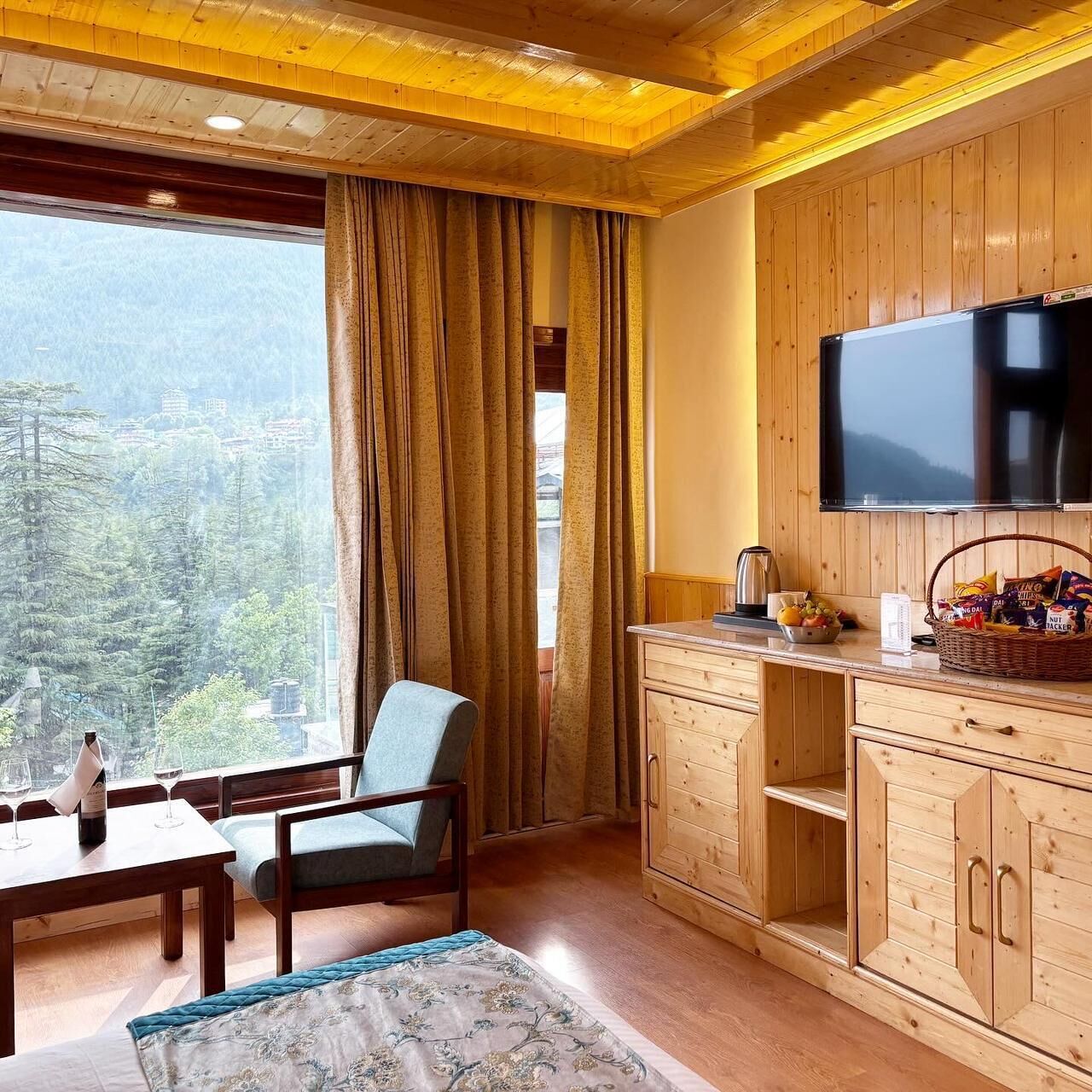 Una habitación acogedora con muebles de madera, televisión y ventana con cortinas.