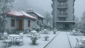 A building with a central courtyard, surrounded by snow-covered trees and a paved walkway. - Snow Park Villas & Resort Manali (Manali)