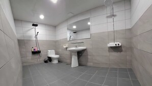 Een moderne badkamer met toilet, wastafel en douche.