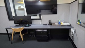 Een werkplek met een bureau, computer, stoel en persoonlijke spullen.