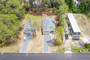 An aerial view of a residential area with two houses, a driveway, and a parking lot. - Mid Term Home in Southport, just mins from DT Southport and Oak Island Beaches (Southport)