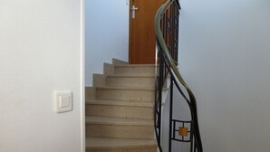 A staircase with beige steps and a black metal railing.