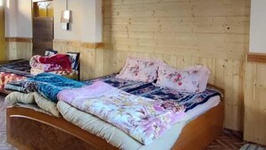 A bedroom with a wooden bed, a herringbone-patterned floor, and a wooden ceiling. - Buddha Home Stay Kaza (Kaza)