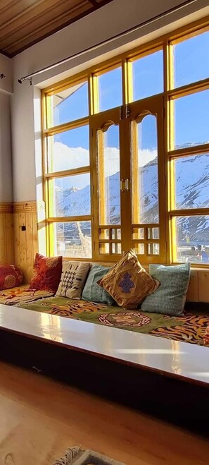 A room with a large window overlooking a snowy mountain.