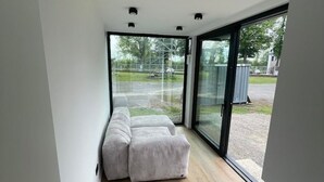 A modern room with a large sliding glass door leading to an outdoor area.