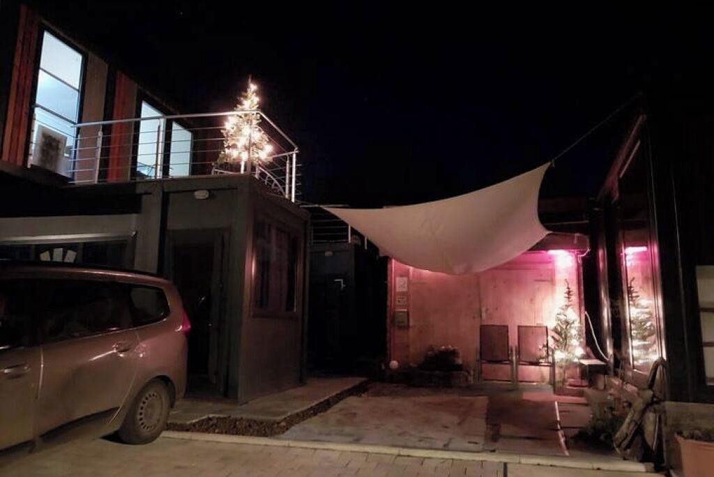 A building with a balcony and a covered outdoor area at night.