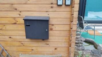 Un muro in legno con un quadro elettrico nero, due dispositivi fissati al muro e un cartello con scritto "BIOTOPIA".