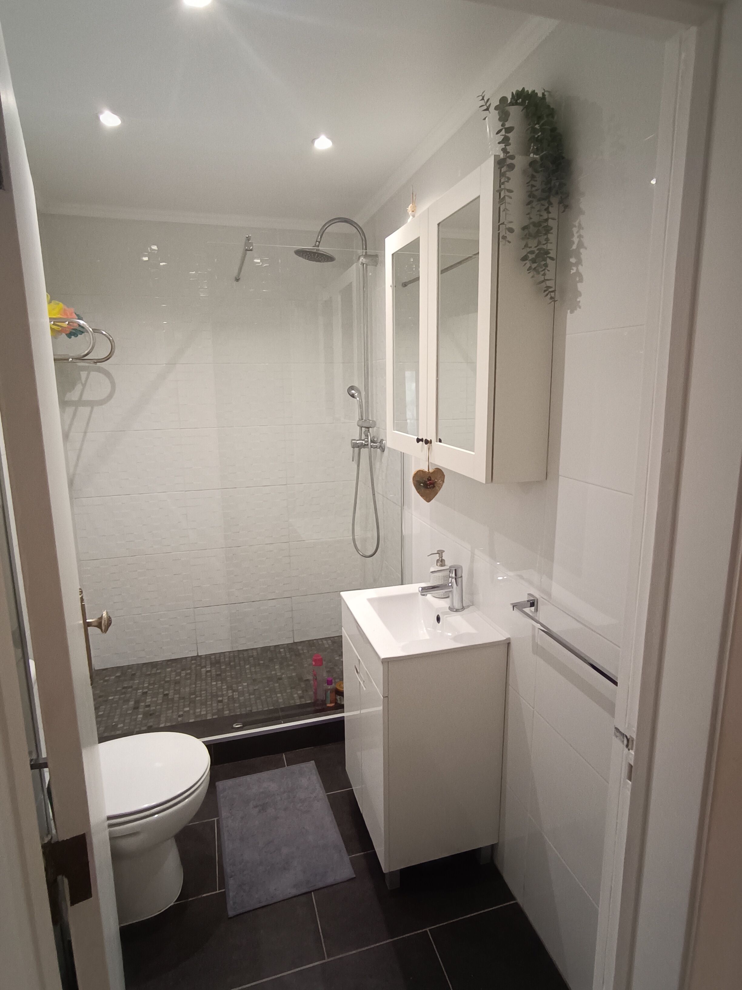 Un baño pequeño con inodoro, lavabo y ducha.