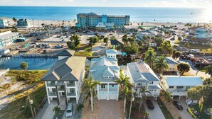 A coastal hotel with multiple buildings, a parking lot, and a beach in the background. - Seaside Villa Aqua luxury 4-bedroom villa in Fort Myers Beach incredible view (Fort Myers Beach)