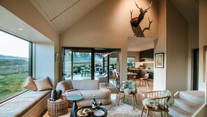 Una sala de estar moderna con un ventanal grande, un sofá, una mesita de centro y una chimenea.
