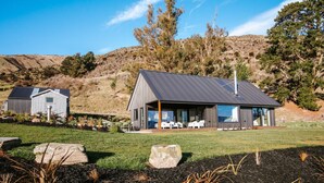 Una casa moderna con un amplio patio, un garaje independiente y un césped bien cuidado.