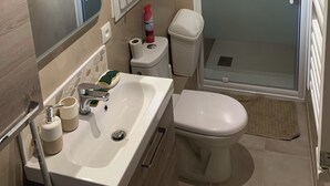 A modern bathroom with a sink, toilet, and glass-enclosed shower. - In the heart of Andernos-les-Bains, 200 m from the beach (Andernos-les-Bains)