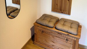 Una habitación con un aparador de madera, un espejo y un panel de madera en la pared.