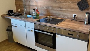 Cocina compacta con lavavajillas, horno y cocina.