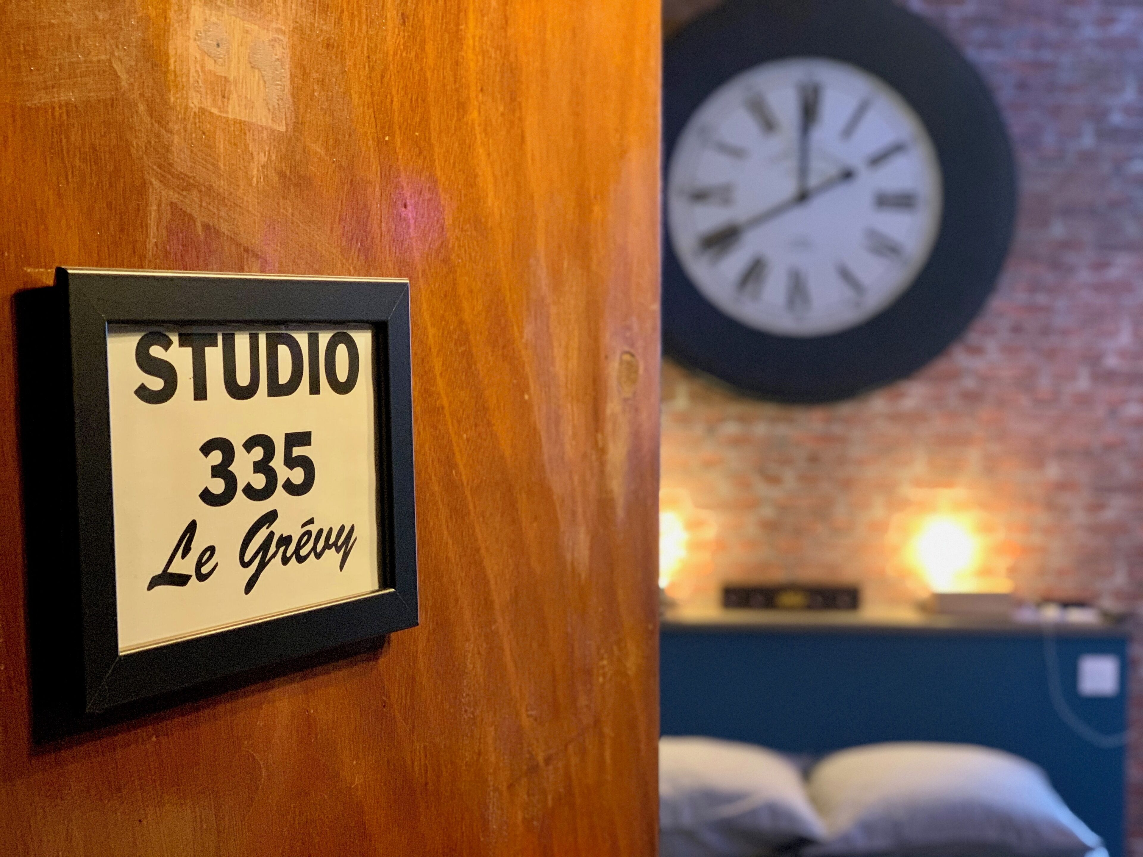 Un cartello incorniciato con la scritta 'STUDIO 335 Le Gravy' su un muro di legno.