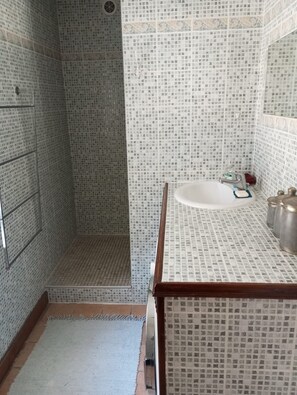Chuveiro, secador de cabelo, toalhas de banho, papel higiênico