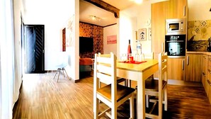 Una cocina moderna con armarios de madera, una mesa de comedor con sillas y una pared de ladrillo.