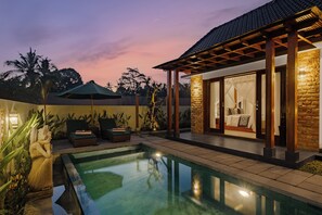 A poolside area with a lounge chair, a covered seating area, and a bedroom with a view of the pool. - Green Weca Ubud Villa (Tegallalang)