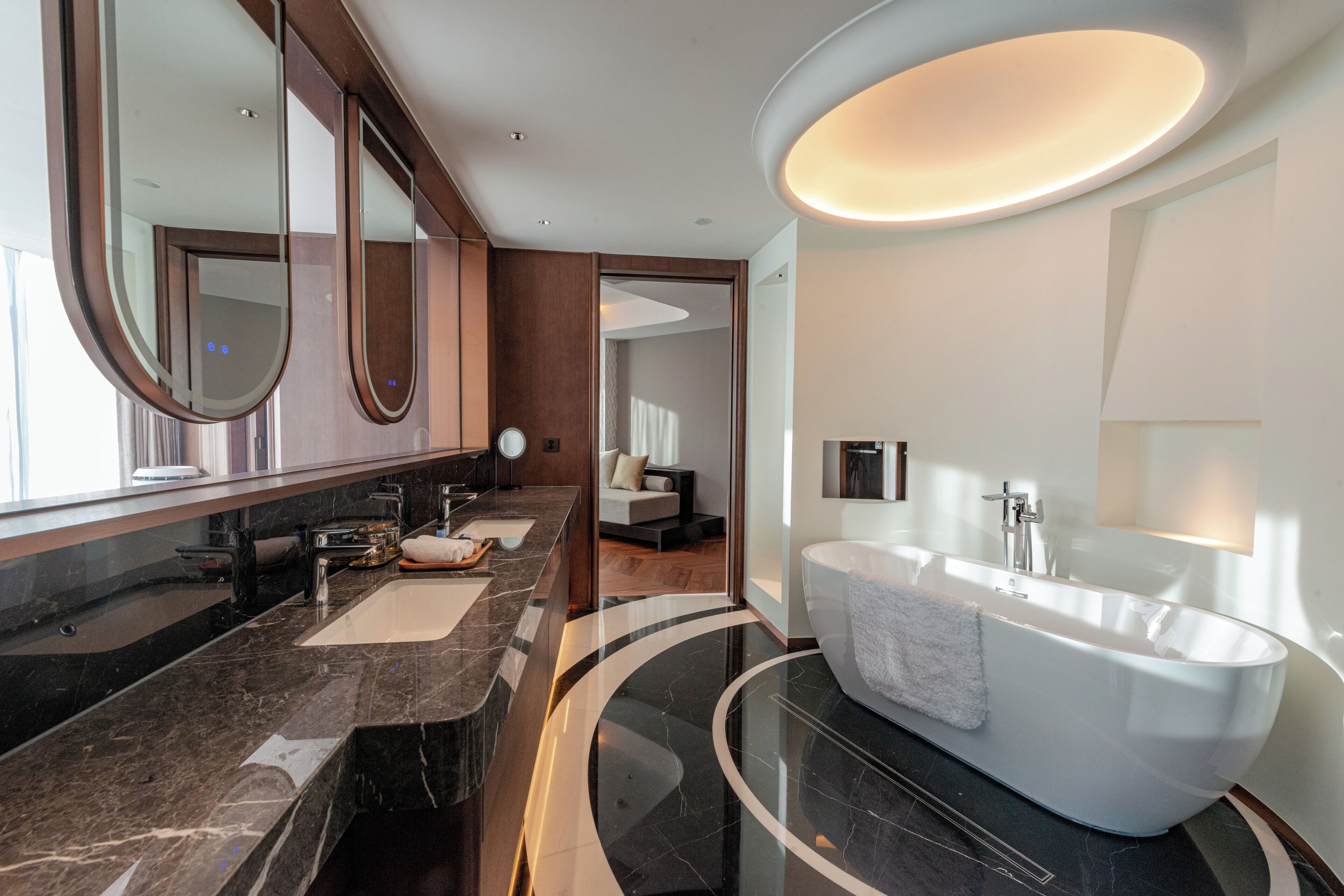 Ein modernes Badezimmer mit einer großen Badewanne, zwei Waschbecken und einem Spiegel.