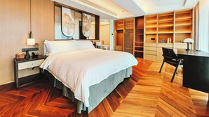 Een moderne hotelkamer met een groot bed, een bureau en ingebouwde kasten.