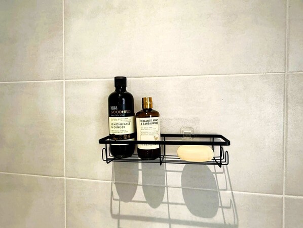 A bathroom shelf with two bottles of body wash and a bar of soap.