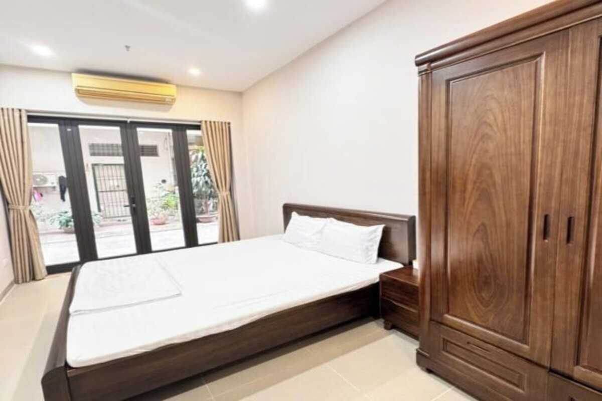 Ein Schlafzimmer mit Bett, Kleiderschrank und einer Glastür zum Außenbereich.