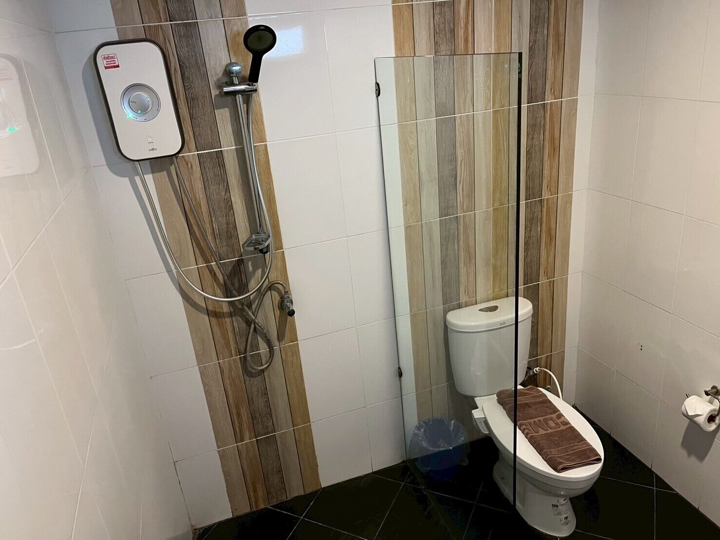 Un bagno con doccia, WC e specchio.
