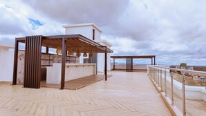 En takterrass med en pergola, en sittgrupp och utsikt över stadsbilden.
