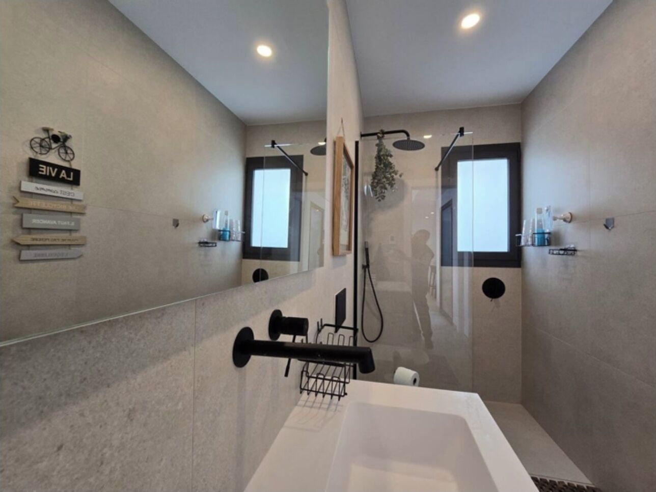 Une salle de bain moderne avec une grande baignoire, un espace douche et un miroir.