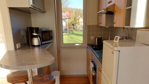 A compact kitchen with a dining area, a refrigerator, a microwave, and a coffee maker. - Small but nice, for relaxing. WWW like forest, water, meadow. (Grünheide (Mark))