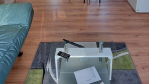 A compact kitchen with a dining area, a small bar table, and a sofa. - Small but nice, for relaxing. WWW like forest, water, meadow. (Grünheide (Mark))