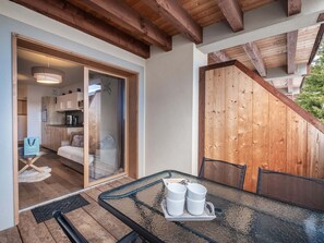 A modern kitchen with wooden cabinets and a sliding glass door leading to a dining area with a glass table and chairs.