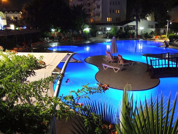 Une piscine avec des chaises longues et un petit pont.