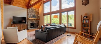 Private lakefront home with dock, forest views, balconies, game room, and cozy indoor charm