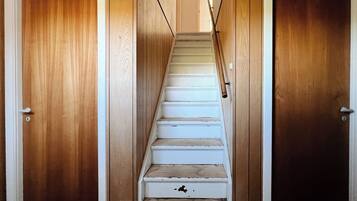 Un escalier aux marches blanches menant à une porte située en haut.
